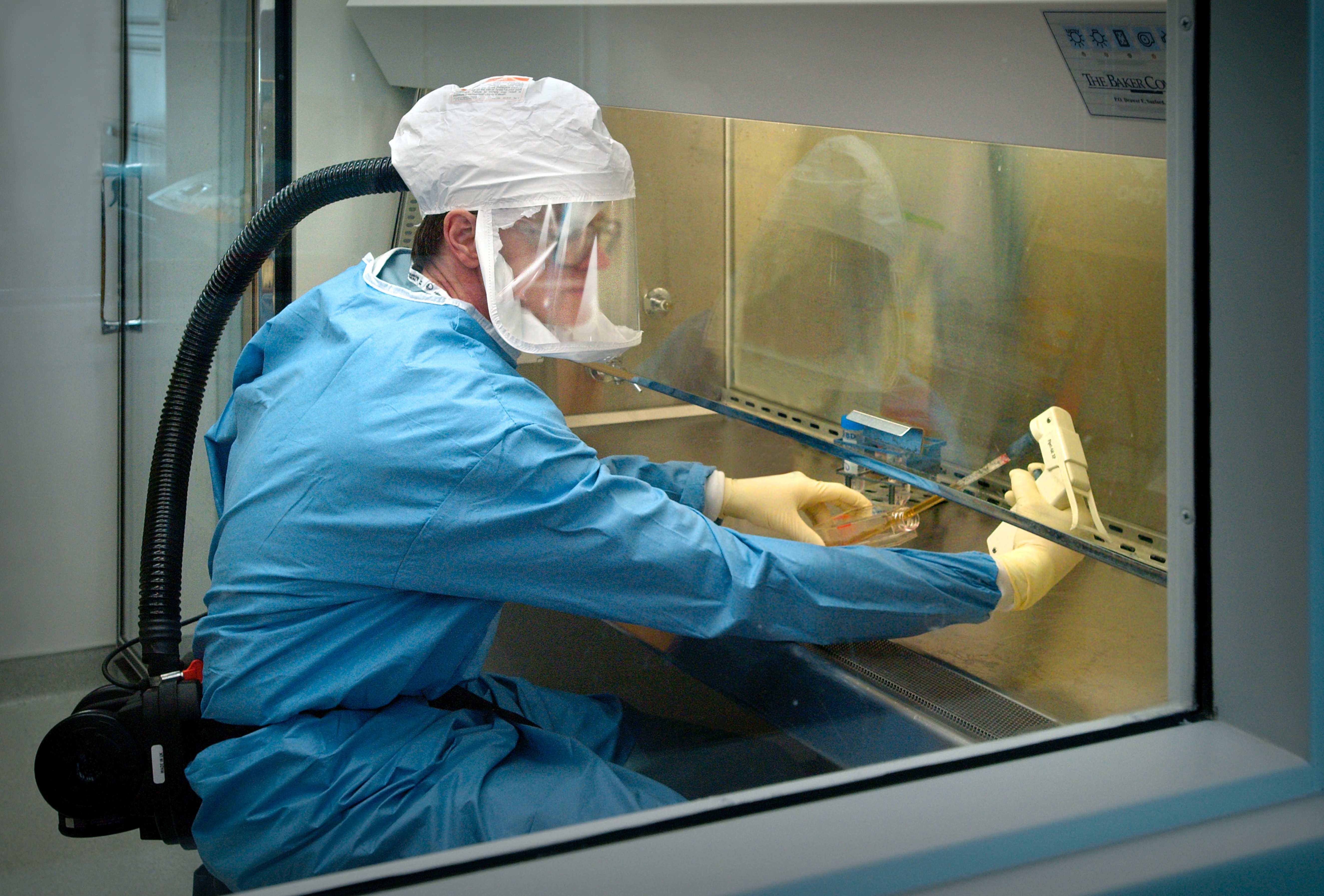 A scientist at the Centers for Disease Control and Prevention, in an Atlanta laboratory, wears a protective air-tight suit when handling samples of influenze.